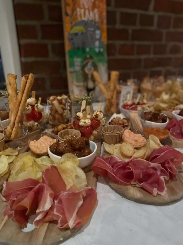 Borrelplank met ham, kaas en hapjes op een houten tafel