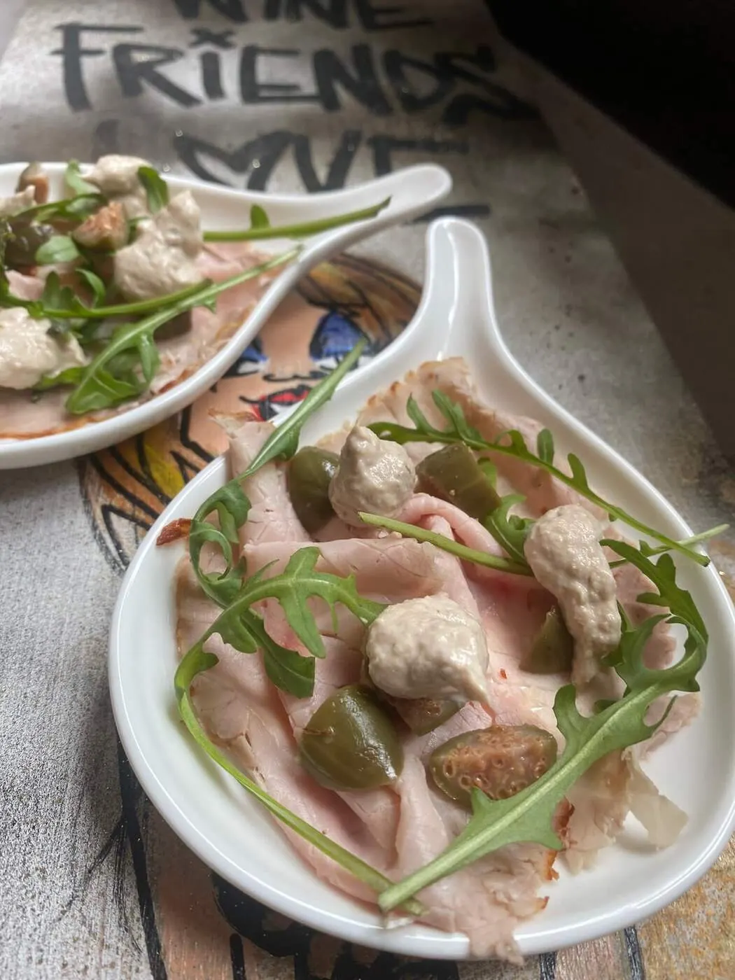 Amuse met carpaccio en rucola in een porseleinen lepel