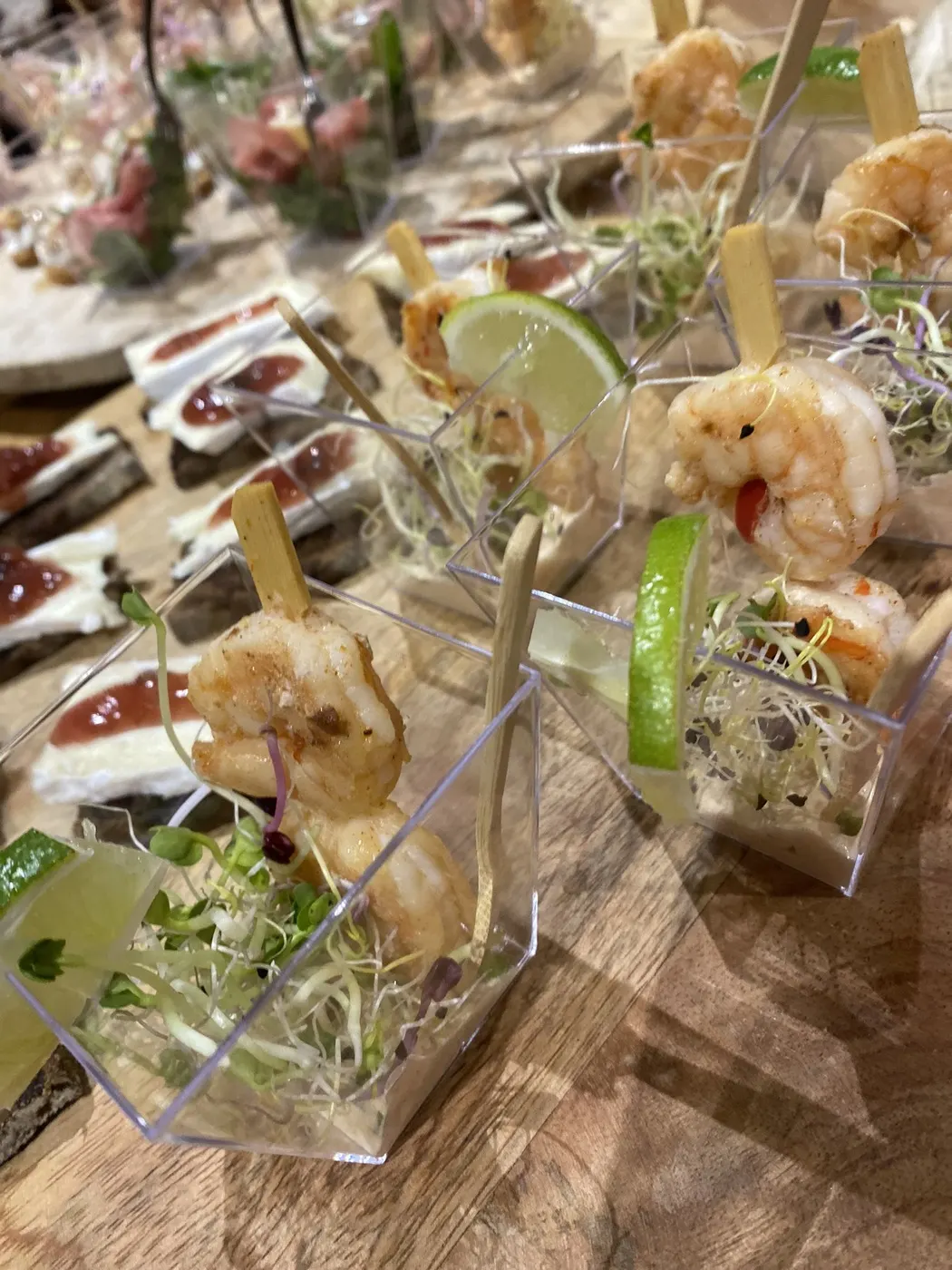 Amuseglaasjes met garnalenspiesjes op een buffet
