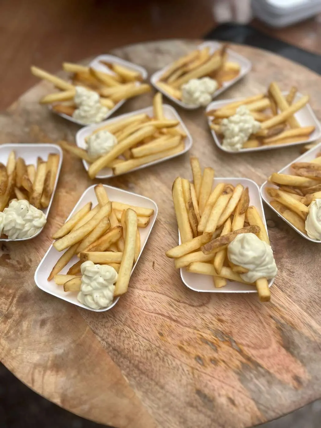 Bakjes verse friet met mayonaise op een houten tafel
