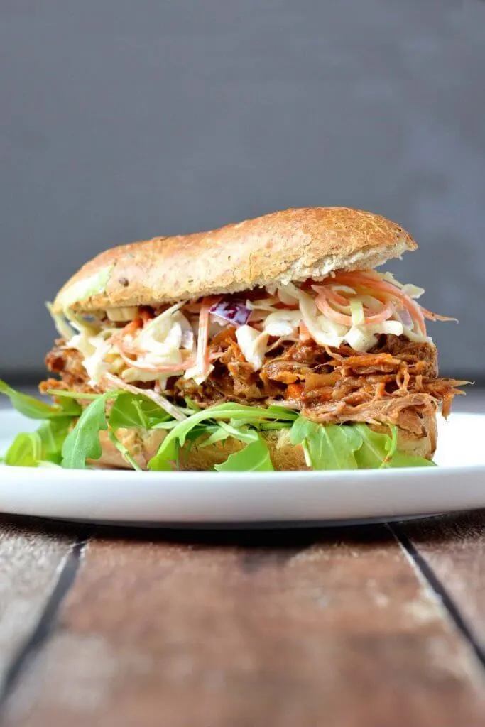 Broodje pulled pork met rucola op een bord