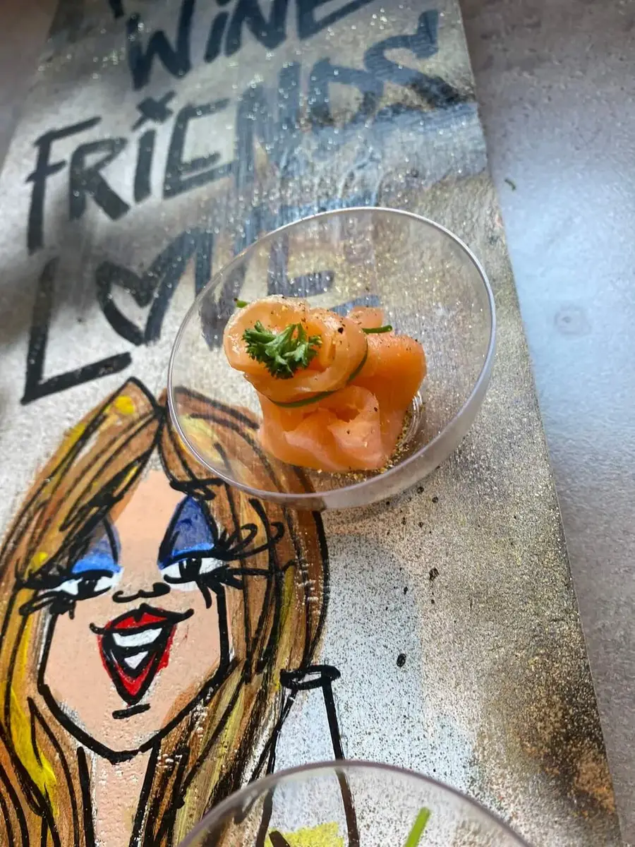 Zalm-amuse op een tafel met handgeschilderde tekst